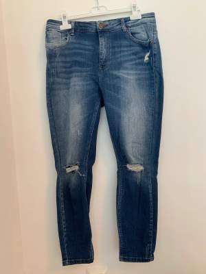 Sparsamt använda, mellanblå jeans från Only i storlek, waist 31, lenght 30. Jeansen har slitningar på knäna och lite vid vänster ficka.