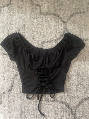 Svart topp - Svart topp med korsett detaljer! Aldrig använd, använd köp nu <3