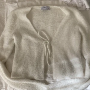 Fluggig tröja - Fluffig tröja från Bershka. Använd en gång. Den har en öppen mage med knytning. Väldigt skön att ha på sig. 