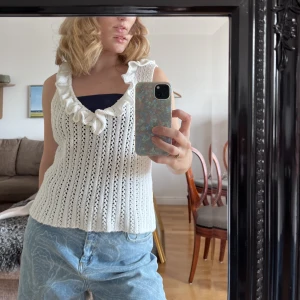 Stickad väst  - Vit stickad väst/kofta! Supersöt med små volanger längst med urringningen! Snygg att ha över en skjorta eller bara som den är! Köpt på en secondhand i Oslo! 
