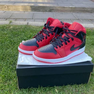 jordan 1 mid red - Storlek 43, Nyskick. Säljer då jag behöver pengar för annat, köpte av kompis alla qr koder skannar och skorna är äkta. Säljer i behov av pengar och att det inte passar. 