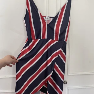 Blå/röd kort klänning  - Klänning från Linn Ahlborg x Na-Kd, ena axelbandet har lossnat men det ska inte va något problem att sy fast igen om man äger en symaskin. Har fäst med säkerhetsnål själv.