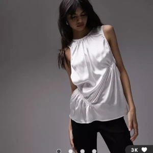 Vacker vit top - En riktigt snygg top i siden i elfenbensvit. Ser väldigt lyxig ut. Den är helt oanvänd då jag råkade köpa två.