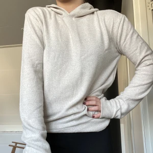 Långärmad tröja med luva  - Beige långärmad tröja i superskönt, mjukt och tunnt material med långa ärmar och luva. Från Gina Tricot. Storlek S