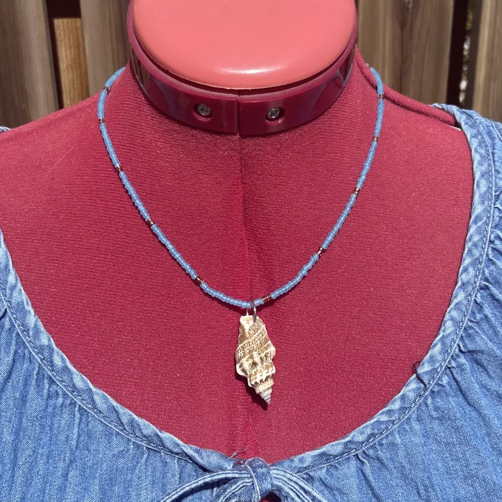 Fint somrigt hemmagjort halsband gjort med smyckeswire, glaspärlor och en snäcka! Mäter cirka 45 cm. OBS! Mät att halsbandet passar innan köp . Accessoarer.