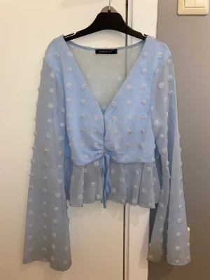 Söt sommarblus - En supersöt blå sommarblus med utsvängda ärmar och söta prickar på. Knappt använd. Köpt på Shein. Storlek S. Pris kan diskuteras