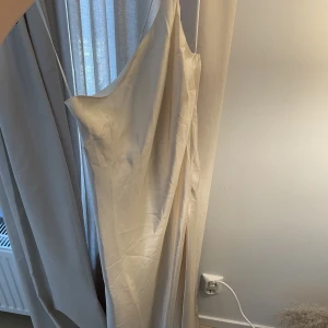 Vit satin klänning  - Superfin vit satin aktig klänning i storlek 38. Klänningen är köpt second hand så vet inte märke. 