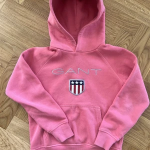 Gant hoodie strl 134/140 - Använd men fint skick. Någon liten fläck här och där, knappt synbart. Fin corall/rosa färg. 