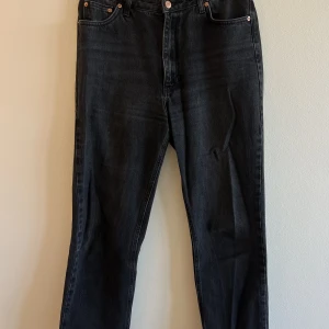 Jeans - Svarta jeans med sliten kant längst ned. Färgen är lite åt det gråsvarta hållet.