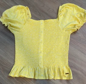 Toop - gul sommartopp med blommönster på. Fungerar både som offshoulder och med axlarna på, är inte genomskinlig, har inga skador (använd 2 gånger) och puffärmarna är en jättefin detalj <3 ordpris 249-: men säljer för 100kr, kom privat för annat pris!