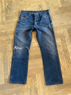 Wrangler Jeans - Raka Wrangler jeans i vacker blå/svart tvätt. Snygg passform! Det står att storleken är 32 X 34 men skulle säga att det är en 32 X 30. 