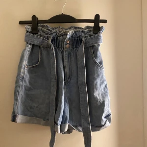 Jeans shorts - Aldrig använda jeans shorts med bälte från H&m. Nyskick.