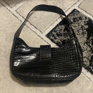 Axelväska - Svart axelväska, ej använd lagom utrymme med en ficka i väskan