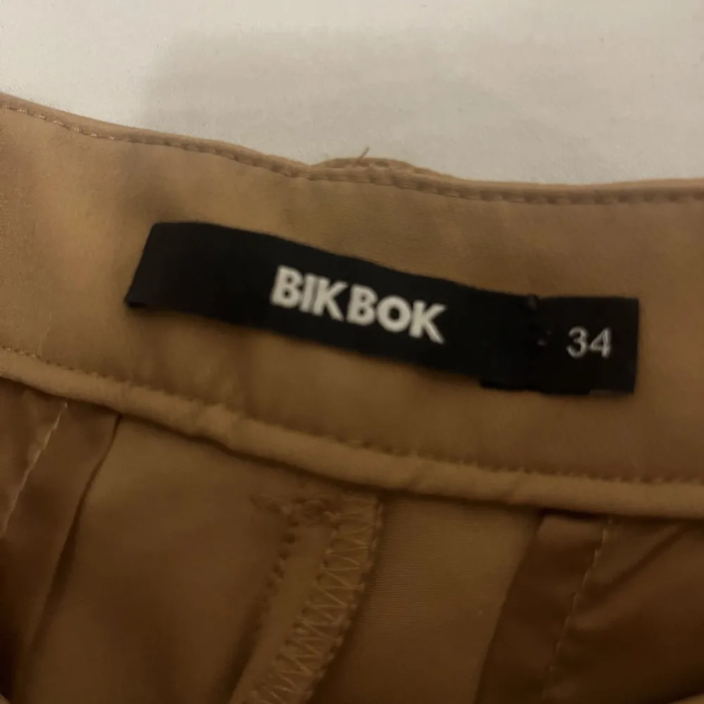 Beige/bruna bootcut kostymbyxor från bikbok.. Jeans & Byxor.