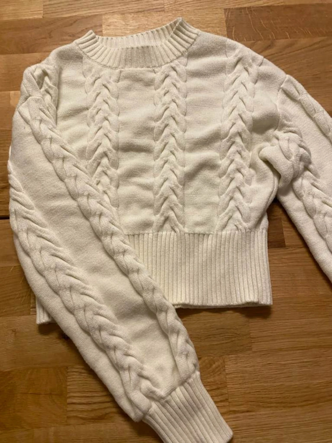 Vit stickad tröja med flätor