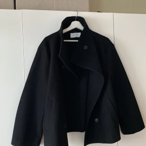 Kort kappa - Superfin kort svart kappa från Bubbleroom! Endast använd 1 gång så ser helt ny ut! Den känns lyxig i materialet. Inköpt för 899 kr