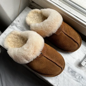 Bearpaw tofflor - Fårskinsstofflor med mockaöverdrag från märket Bearpaw. Amerikansk storlek 7, passar runt 38. Inte använda särskilt mycket, fortfarande fint skick. Nypris ca 700, säljer för 300kr.