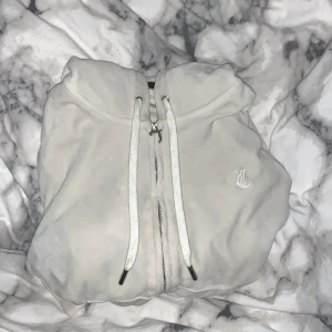 vit juicy coutoure zip up hoodie - Säljer min vita juicy coutoure zip up hoodie. Hoodien är i storleken L men passar mig bra som i vanliga fall har S och sällan M i tröjor. 