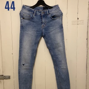 Jeans - Tiger of Sweden - Herrjeans i tight modell. Litet hål på ena knät. 