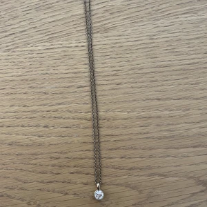 Halsband  - Väldigt fint hängande halsband från Dyrberg/Kern med en Swarovskikristall. Färgen kommer inte fram så bra på bild men det är en guldfärgad stål. Nypris 600kr. 