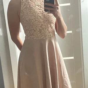 Klänning  - Rosa klänning med paljettmönster på överdelen. Knälång. Jag är 170cm lång för referens.   