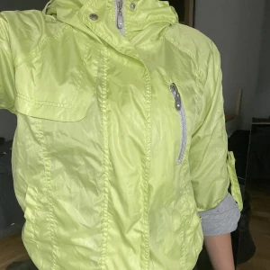 Regn jacka  - Lime grön regnjacka, lite liten för mig ärmarna går att knäppa upp till full längd  