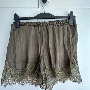 Olive green shorts with lace trim and pockets. 