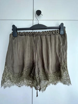 Olive green shorts w. Lace - Olive green shorts with lace trim and pockets. 