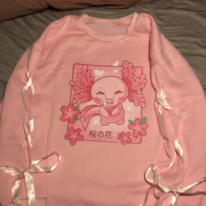 Rosa axolotl tjock tröja - En rosa varm tjock tröja som knappast är använd, har fina snörningar på armarna