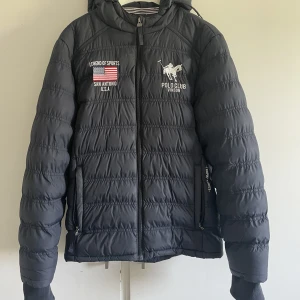 Polo club jacka  - Marinblå polo club jacka i storlek 160. Bra skick, det ena bandet som man spänner in den med är av, annars bra skick.