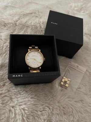 Marc Jacobs klocka - Klocka i guld, använd enstaka gånger och inga repor/skador. Batteriet behöver bytas. Säljer då den inte kommer till användning. 