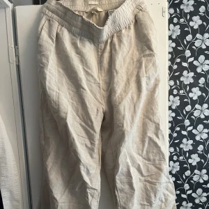 Linnebyxor med raka ben - Beigea linnebyxor med raka ben och stretchiga midja. Köpta på HM men nästan aldrig använda. Storlek M.