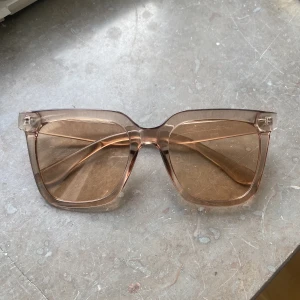 Solglasögon  - Helt oanvända solglasögon i rosa/genomskinlig färg. Jättefina som sitter bra och stabilt. 
