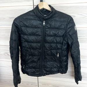 Moncler dunjacka - Svart tunn dunjacka från Moncler. Säljs till bra pris! Super litet hål finns på jackan men de syns inte.