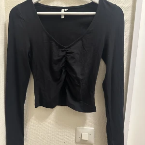 Topp från Nelly  - Svart topp från Nelly med rynkig framsida. Väldigt fin att både ha till vardags och en utekväll. Använt några gånger bara men är i dina skick. 