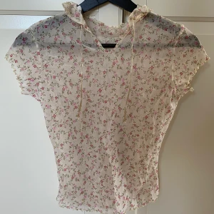 Blommig topp - Supersöt topp, står inte storlek men skulle säga att det är ungefär xs