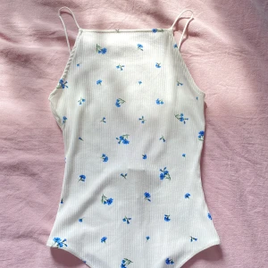 Body med blommor - Body med blommor och öppen rygg från hm som aldrig blivit använd🪩💐