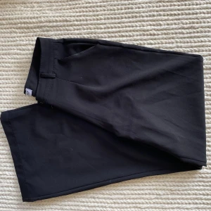 Svarta kostymbyxor  - Svarta,  raka, klassiska kostymbyxor från Madlady. Går precis till foten på mig som är 171. Sparsamt använda. Justerbara i midjan.