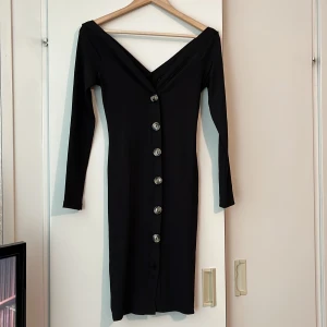 Klänning  - Tight klänning från Gina Tricot med knappar. Väldigt fin V-ringad både fram och bak. Stretckight material. Passar bättre en M eller väldigt kurvig S.  (Sista knappen har lossnat/försvunnit. Kan hitta likande och sy fast om köparen vill.) Använd fåtal ggr.