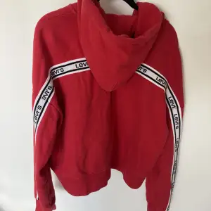 Röd hoodie från Levi’s. Inte mycket använd men lite lite urtvättad.  Dragkedja och något croppad+oversize passform