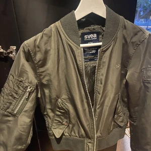Svea Bomberjacka - Millitärgrön bomberjacka från Svea. Välanvänd men i jättebra skick!