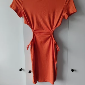 Orange klänning  - En orange klänning med indragning i midjan, går att justera.   Från Shein i storlek Xs.