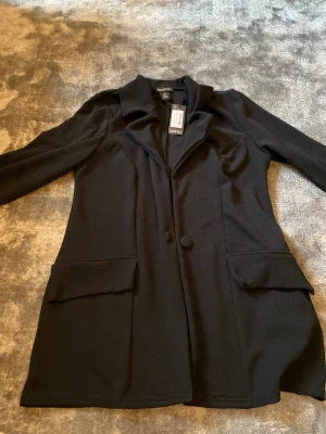 Svart kappa - en svart tunn kappa eller kavaj. köpte den men fick aldrig chansen att lämna tillbaka. 