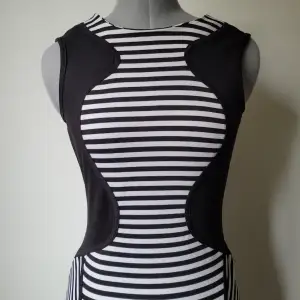 Randig bodycon klänning med smickrande optisk illusion i designen. 83 cm lång.