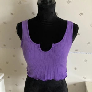 Lila linne - Oanvänd ribbad lila topp med fin urringning. Säljs då den inte kommer till användning. 