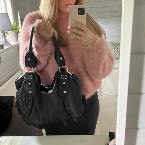 Skolväska - Säljer min ganska nya svarta lite större väska, perfekt till skolan, snygg med silverditaljer🌸inga difekter. Finns ett långt band och två kortare.