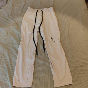 A Cold Wall x Nike byxor  - Acw x Nike byxor. Lång drawstrings. Med resor i knävecken och zips nere.