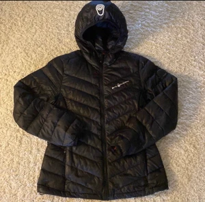 Svart Sail racing jacka i fint skick! - Svart Sail racing Lättviktsdunjacka, använd men i fin skick!   Inga hål eller liknande defekter   Storlek M dam  Nypris 2799kr