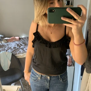 Svart topp - Jättesnygg svart topp med volang från Na-kd!💕💕passar både i vardags och till fest✨✨ I nyskick Storlek 36