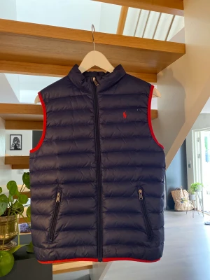 Polo Ralph lauren väst  - Säljer en marinblå polo Ralph lauren väst i storlek 14-16, säljer pga för liten! Säljes i befintligt skick, Nypris 1200kr mitt pris 199kr 